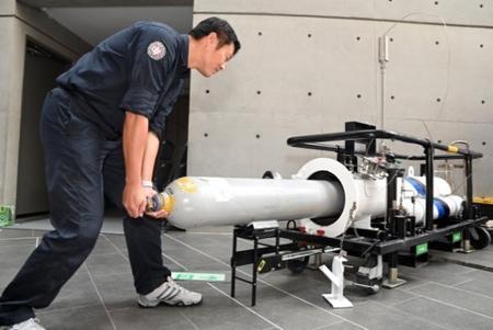
An old cylinder being inserted into an airtight rupture vessel for safe processing.