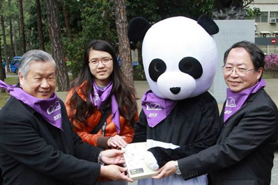 Macronix chairman Miin Wu (left), former NTHU president Chen Lih-juann(陳力俊) (right), a student representative, and the NTHU mascot depositing the final book from the old library into the new library in the Macronix Building in 2013.