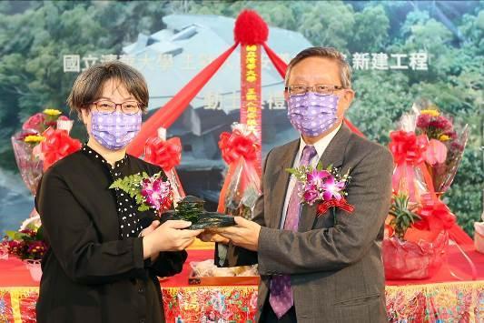 NTHU president Hocheng Hong (right) presenting Wang’s daughter Wang Muchun(王慕淳) with a glass model of the building.