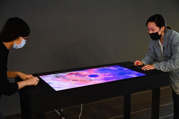 Visitors playing a game of cosmic table hockey.