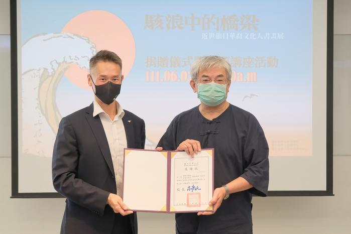 Kao (left) presenting Yang with a certificate of appreciation. 