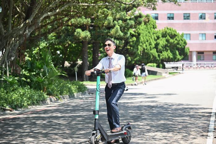 President Kao riding an electric scooter in a film welcoming the new students.