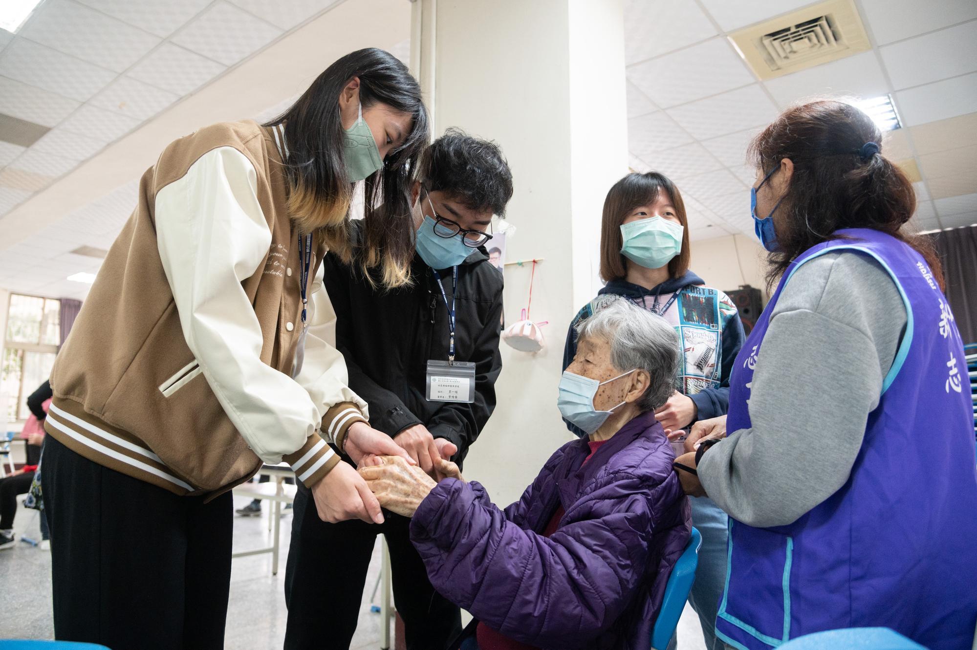 NTHU students with an elder at the Lezhi Learning Center in Zhongshan Village.