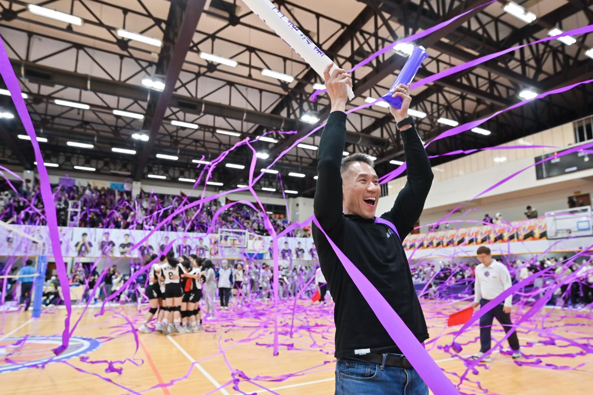 NTHU president W. John Kao (高為元) celebrating the victory, with the women’s volleyball team in the background.