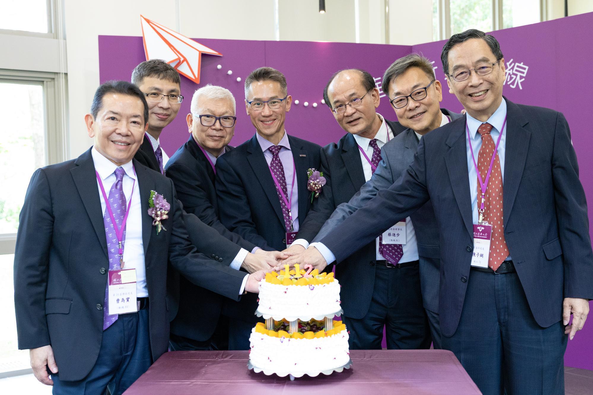 Kao (center) and alumni cutting the anniversary cake.