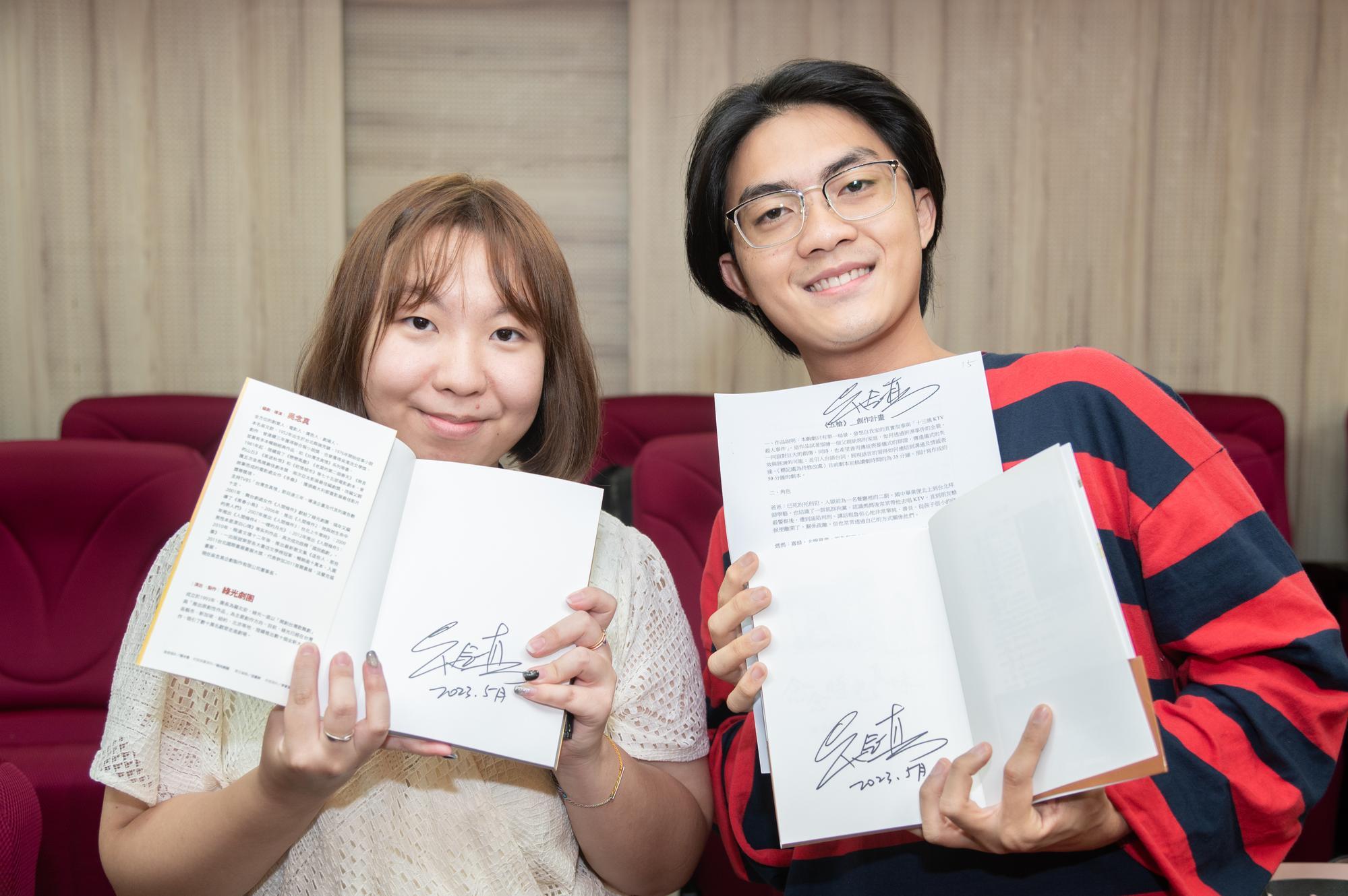 Cypress Su (蘇柏蓁) (left) and Jui-chen Hong (洪睿辰) show Nien-jen Wu's signature on their copies of his works.