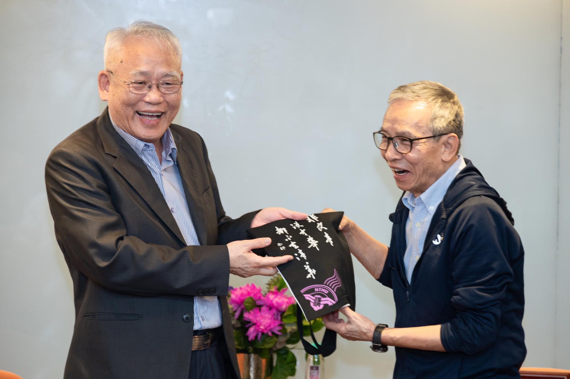 NTHU Senior Vice President Nyan-hwa Tai (戴念華) (left) presents the letter of appointment to Nien-jen Wu (吳念真) as writer-in-residence 2023.