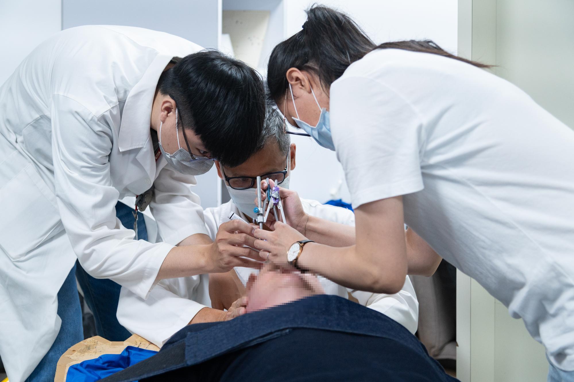 The doctor marking the area on the brain cancer patient where the neutron beam irradiation would be applied.