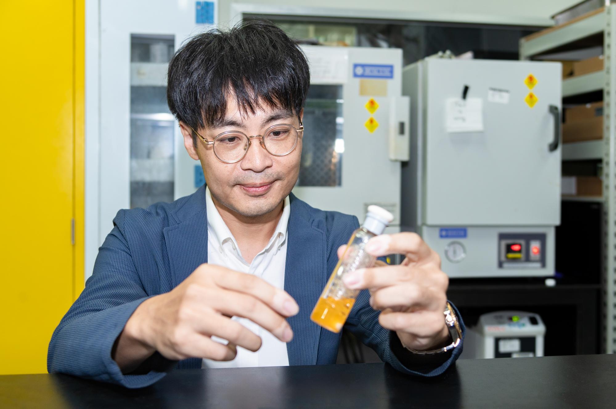 The hydrogen production flask held by Prof. Ho-Hsiu Chou (周鶴修) from NTHU's Department of Chemical Engineering symbolizes the promise of clean energy.