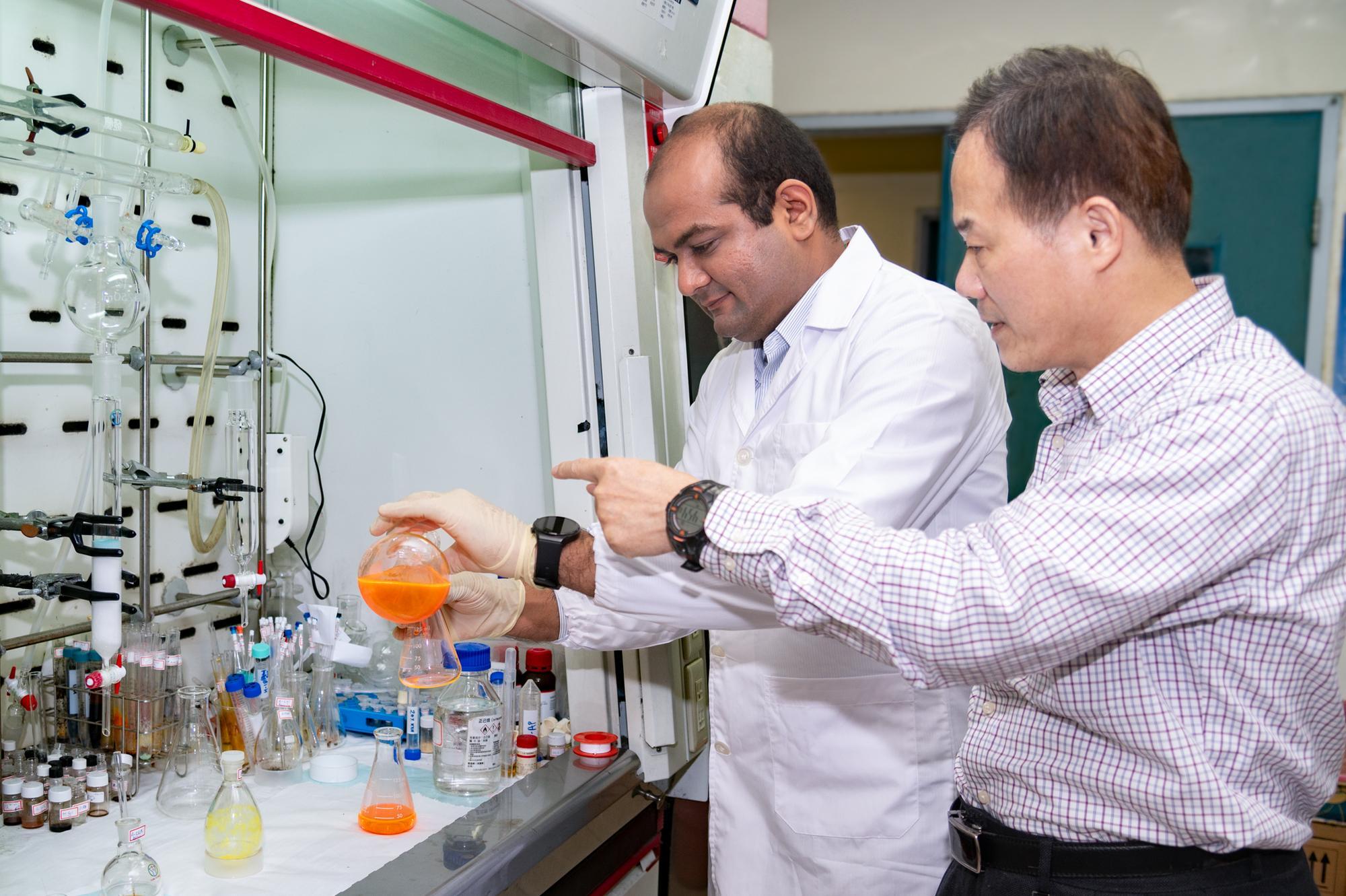 NTHU Distinguished professor Kuo Chu Hwang (黃國柱) (right) and postdoctoral researcher Vaibhav Pramod Charpe employ photochemical reactions to degrade persistent organic pollutants (POPs).