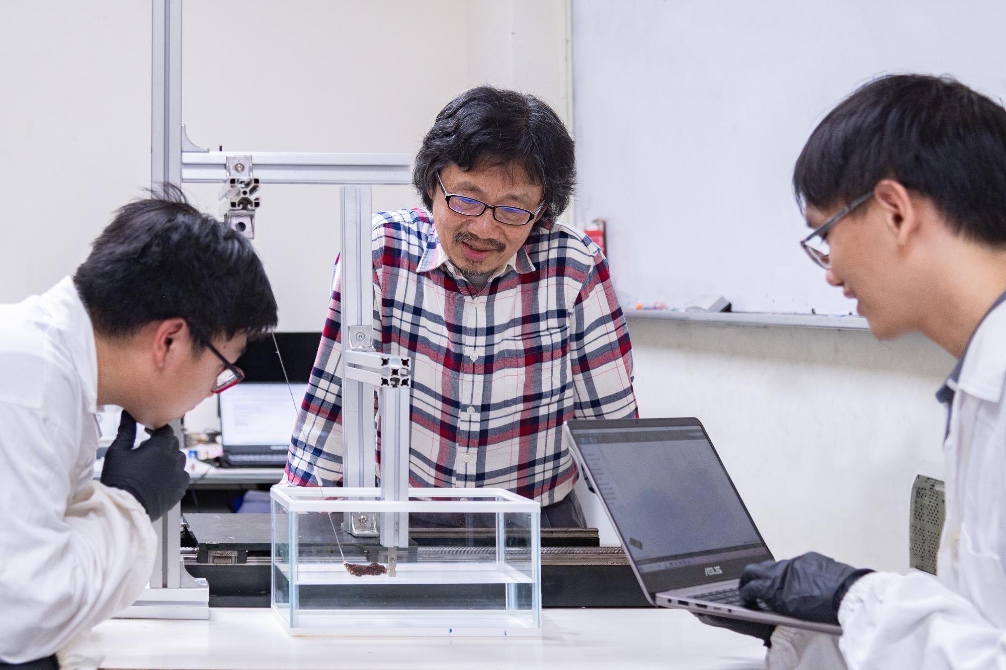 Professor Tzay-Ming Hong (洪在明) (center) from the Department of Physics at NTHU guides graduate students Chung-Hao Chen (陳中皓) (right) and Ting-Heng Hsieh (謝廷珩) (left) in researching the causes of fire ant rafting.