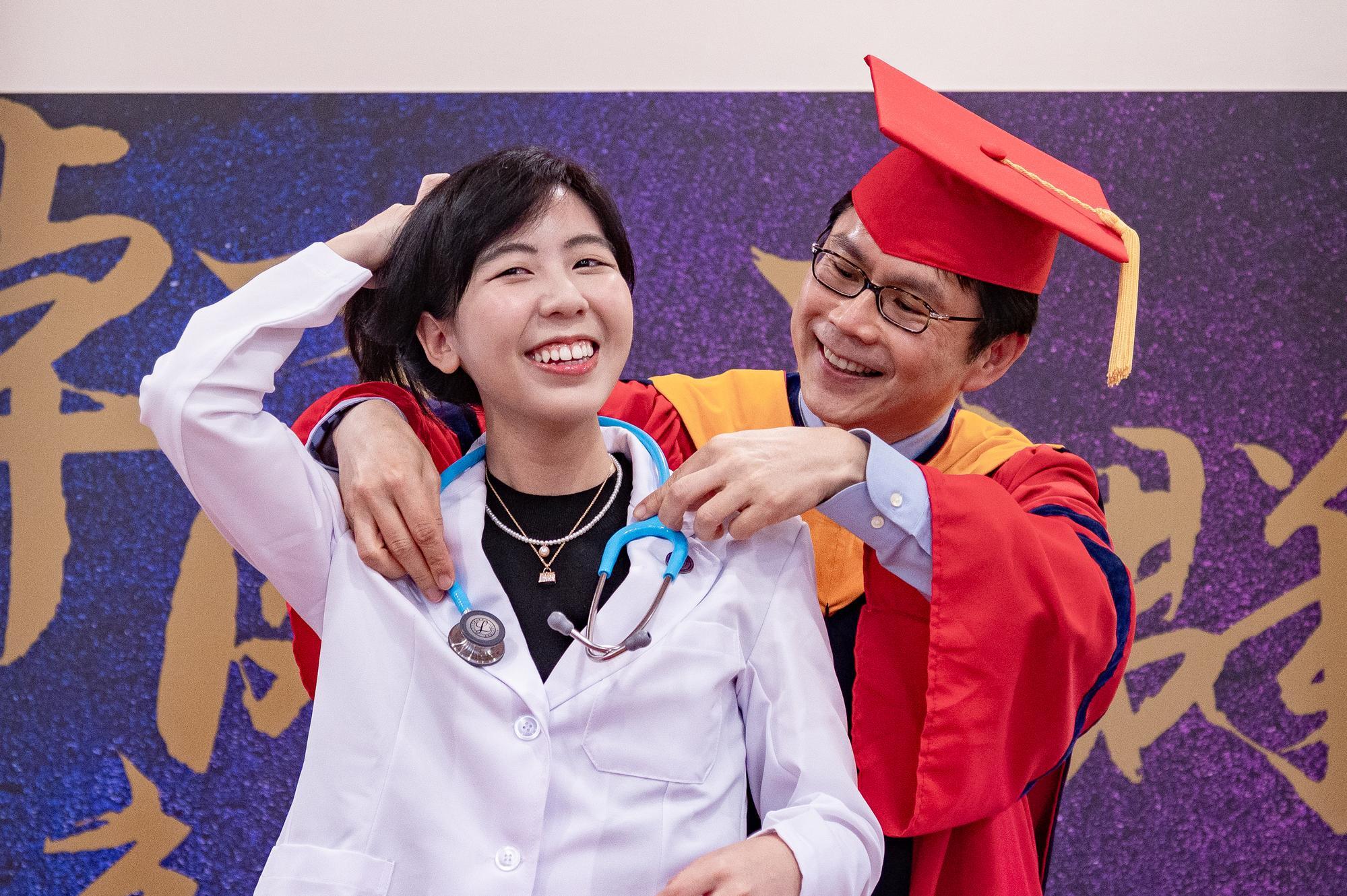 Professor Yung-Jen Chuang (莊永仁) of the College of Life Sciences and Medicine hung a stethoscope around student Yi-Yu Yeh's (葉怡佑) neck.