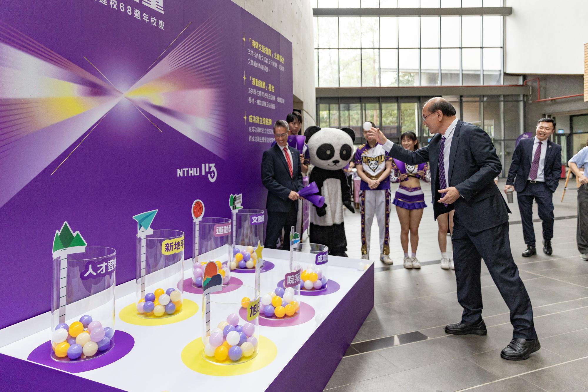 Chairman of the NTHU Alumni Association, Eric Tsai (蔡進步), places an energy ball into the cylinder representing the Renaissance Fund, symbolizing the infusion of new energy into NTHU.