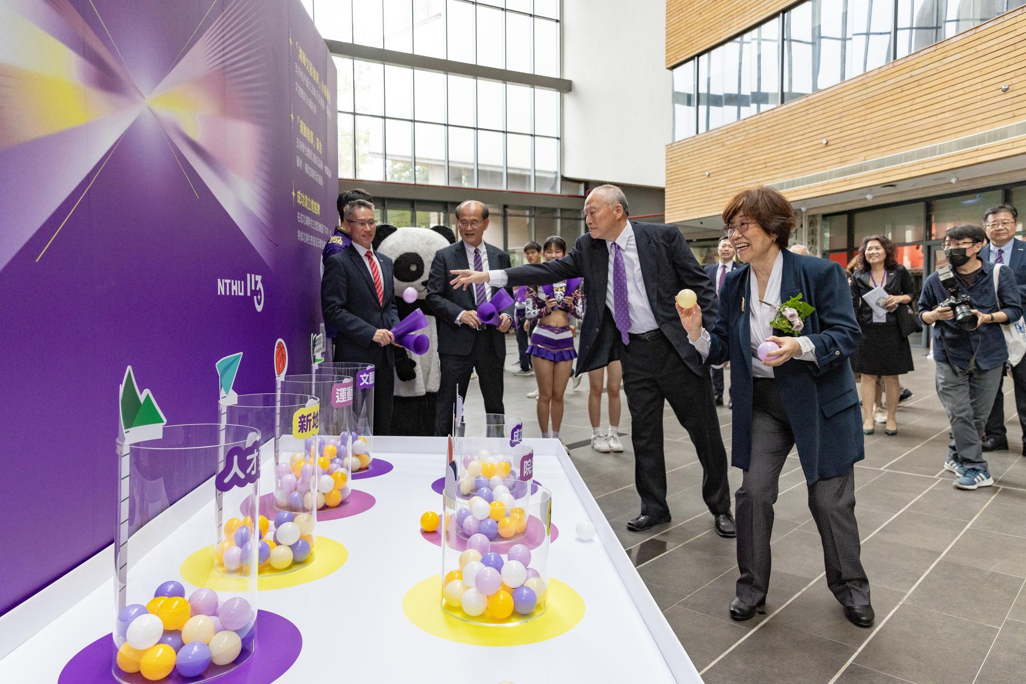 Distinguished alumna Hsiao-Yu Chen (陳筱宇)(right) and her husband Chon-Kwo Tsai (蔡宗國) each place an energy ball into the cylinder representing the Renaissance Fund, symbolizing the infusion of new energy into NTHU.