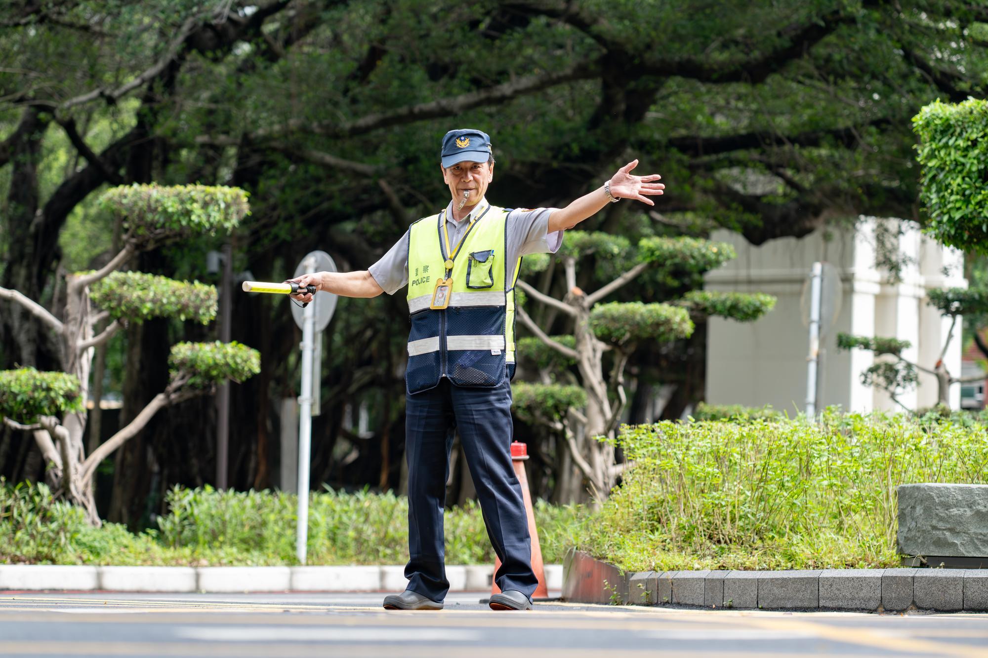 Chao-Hsu Wang (王朝旭), a security guard at NTHU who has served for nearly 30 years, directs traffic on campus.