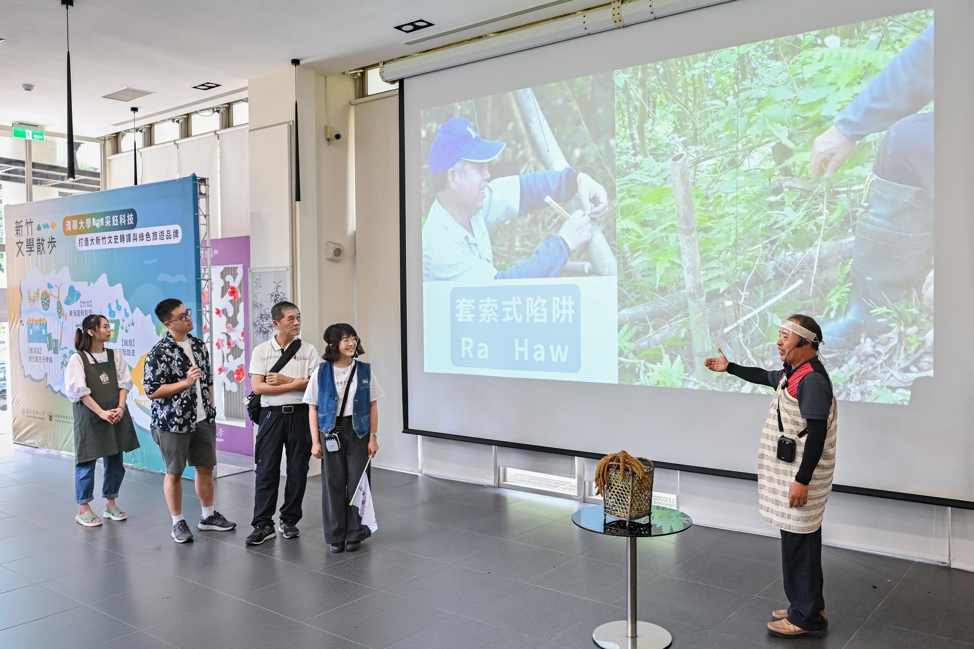 泰雅族邱德昌長老（右）帶貴賓虛實交錯走進尖石馬胎古道。
Atayal elder Pasang Yumin leads distinguished guests on a virtual walking tour of the Matai Ancient Trail at Jianshi.
