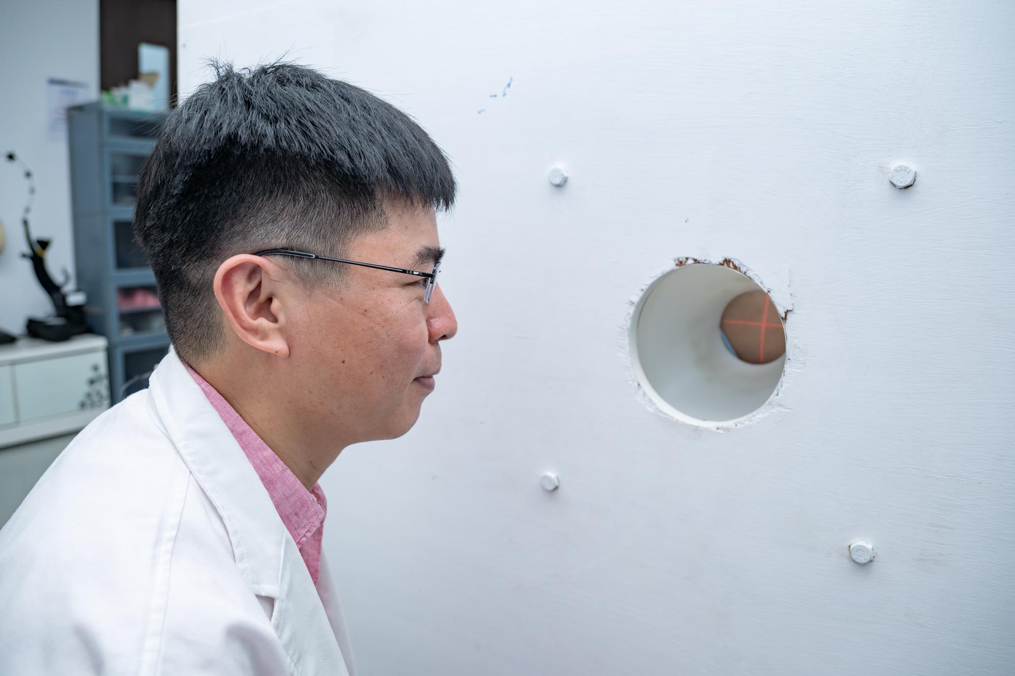 Wen-Ke Chen（陳文科） pinpointing the location where the neutron beam will enter the patient's body in this groundbreaking joint research conducted by NTHU and Mackay Hospital.