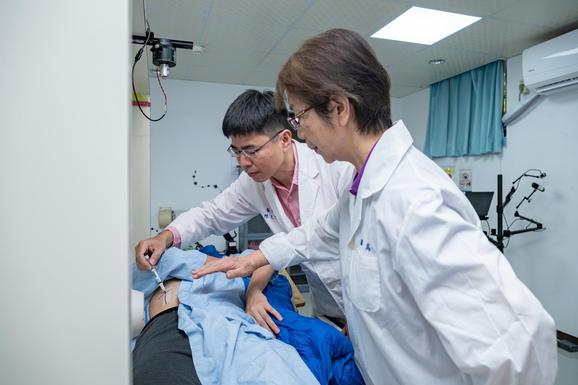 NTHU's Fong-In Chou（周鳳英） (right) and MacKay's Wen-Ke Chen（陳文科） showing where the neutron beam will enter the patient's body.