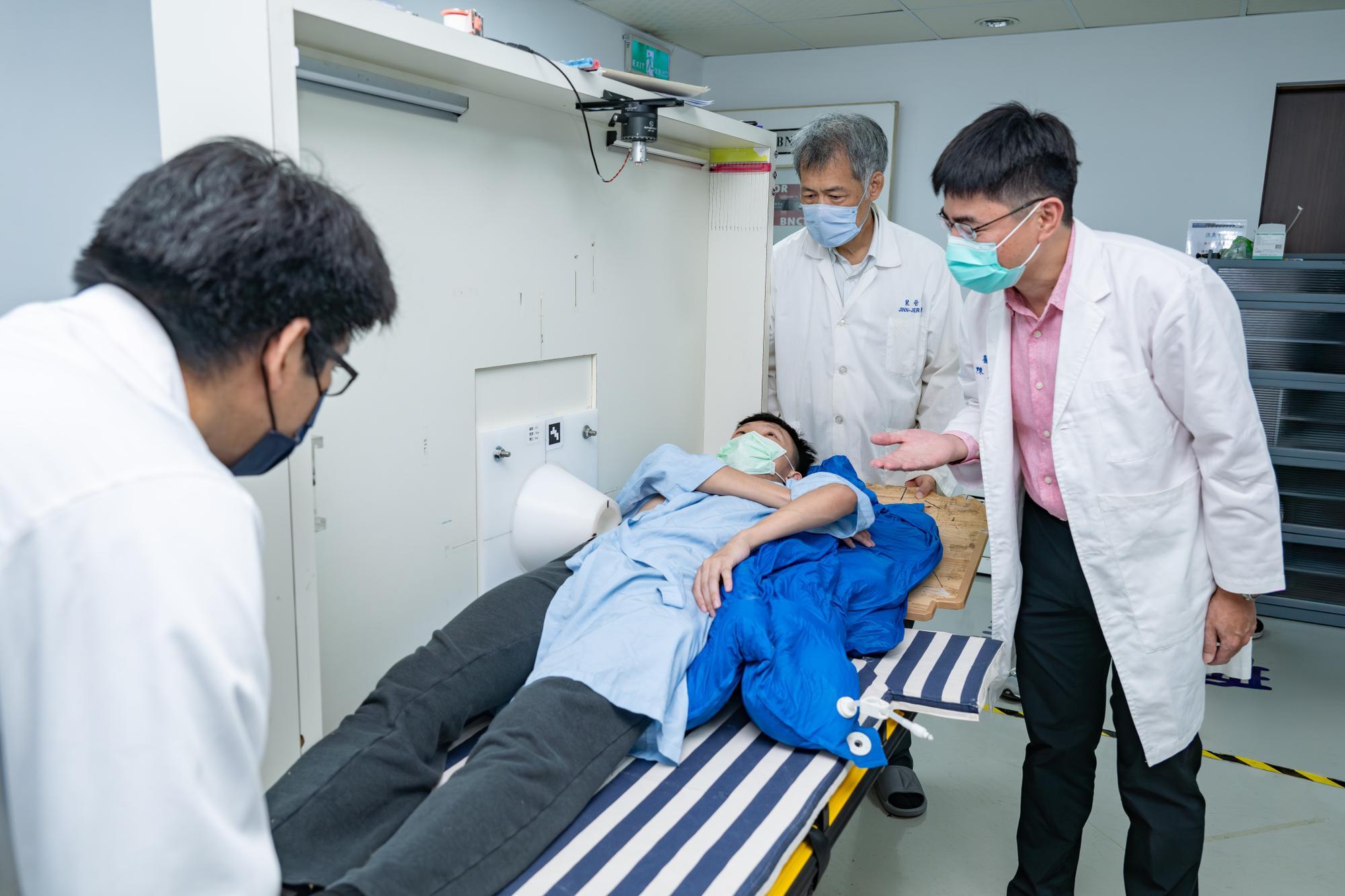 Wen-Ke Chen（陳文科） (right) with Jinn-Jer Peir（裴晉哲） and Yung-Shin Tseng（曾永信） of the NSTDC at NTHU showing where the neutron beam will enter the patient's body.  