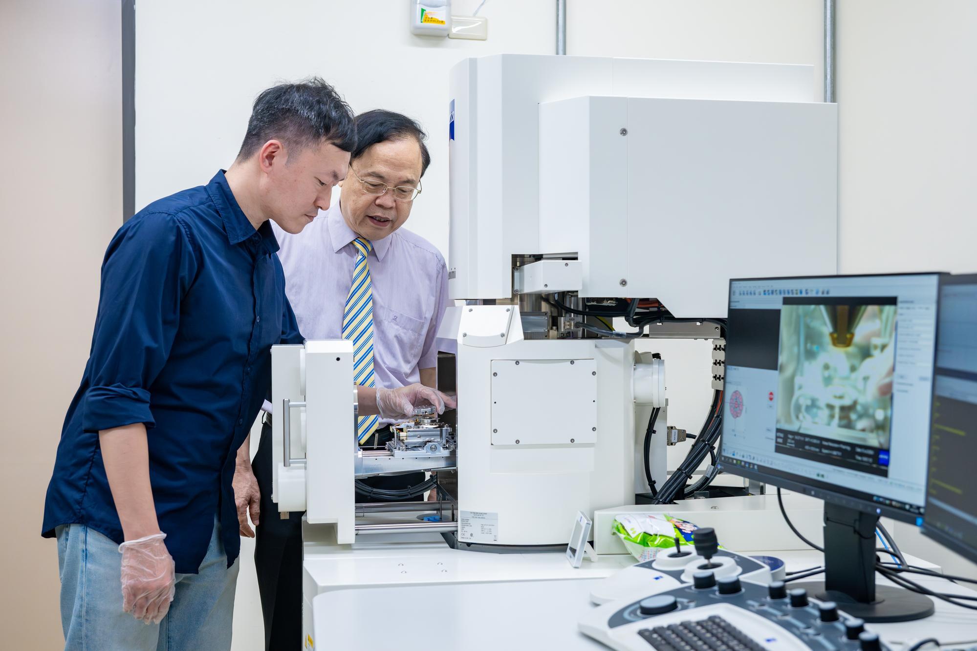 Jien-Wei Yeh (葉均蔚) (right) and Wei-Lin Hsu (許瑋麟) placing a high-entropy alloy inside a scanning electron microscope.