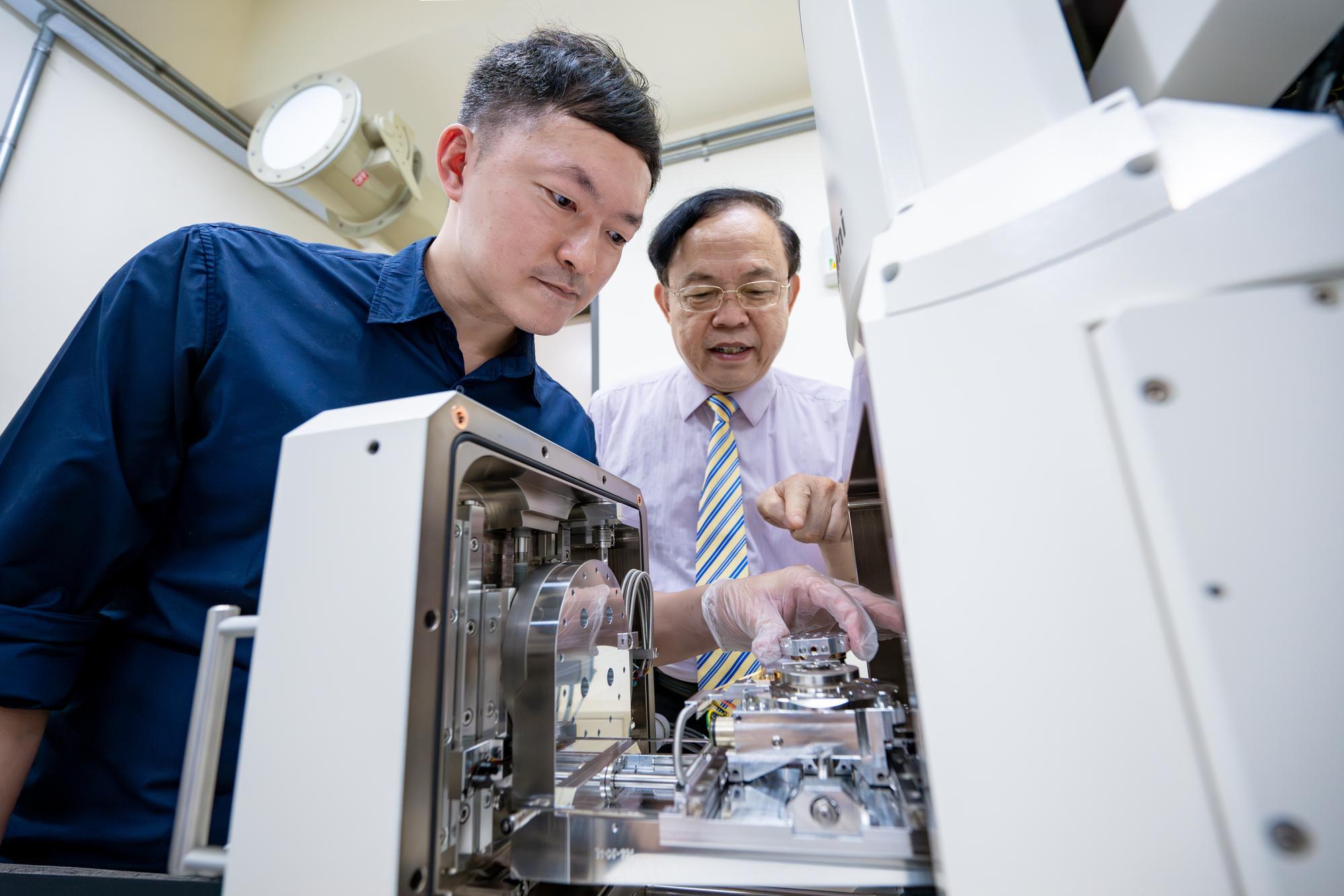 Jien-Wei Yeh (葉均蔚) (right) and Wei-Lin Hsu (許瑋麟) placing a high-entropy alloy inside a scanning electron microscope.