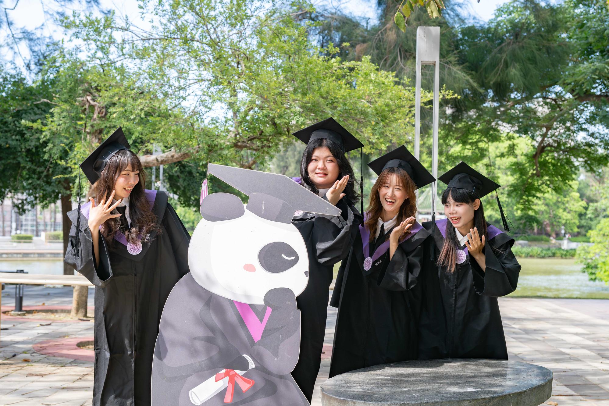 Graduates take photos at the university's commencement-themed installation, capturing memories of their graduation day.