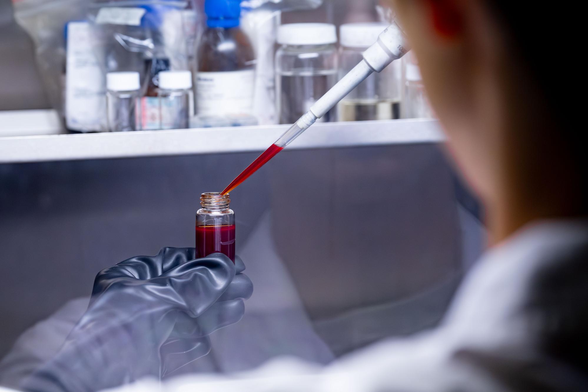Researchers use a micropipette to handle a deep-red perovskite quantum-dot solution during a key fabrication step for the single-photon source.