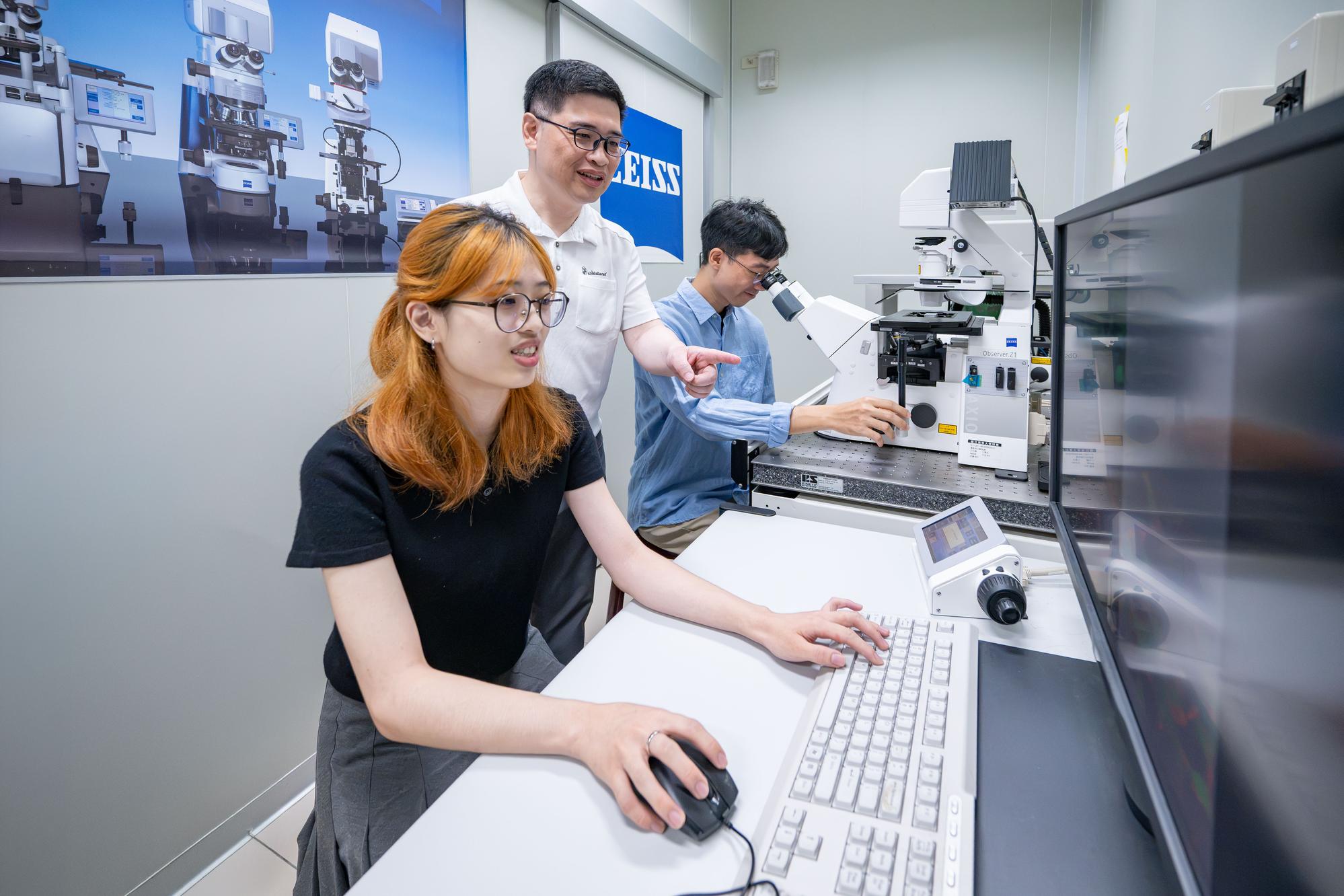 Professor Yun-Wei Chiang (江昀緯, center) and his team observe changes in intracellular calcium levels under a microscope.