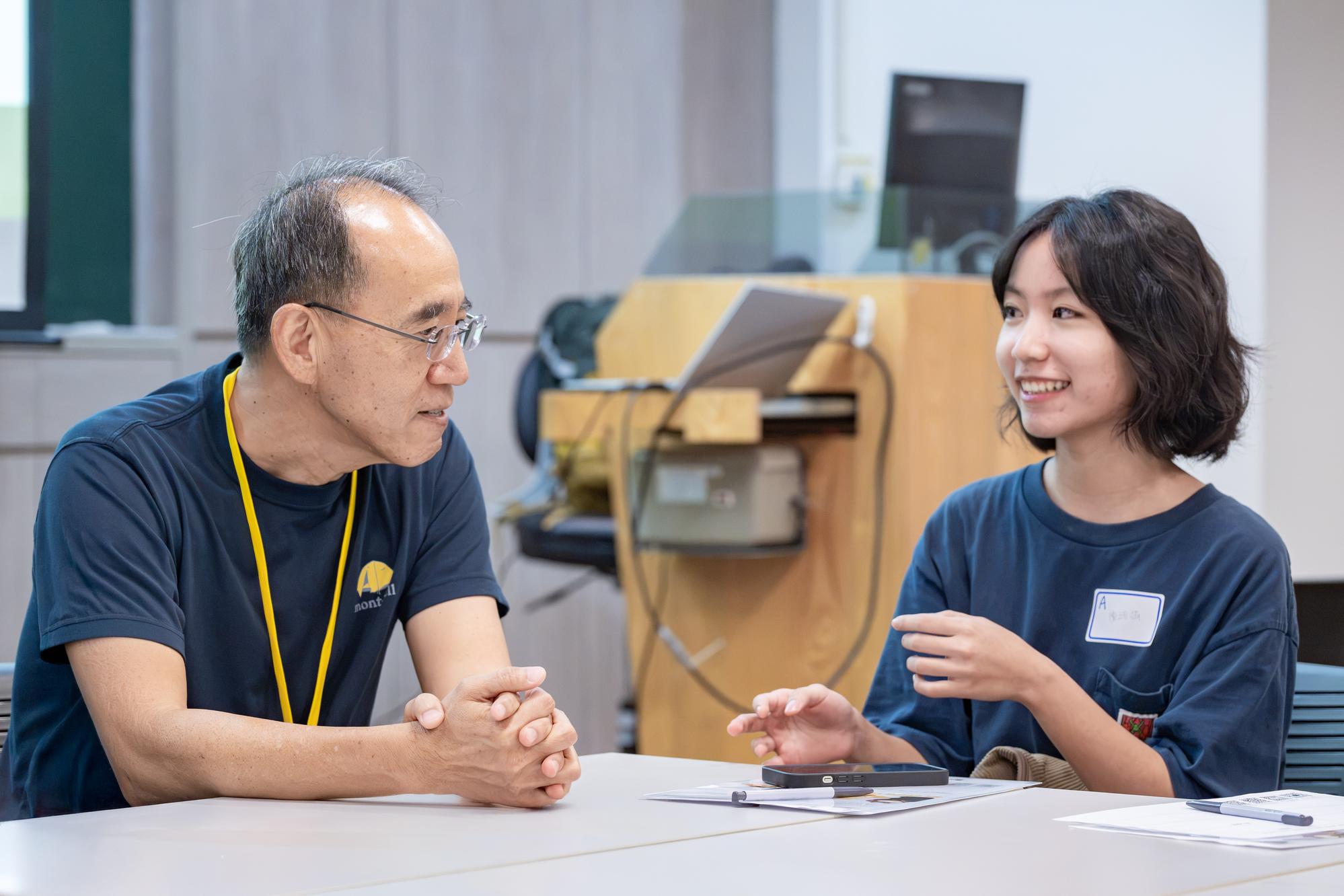 Distinguished Professor of Life Sciences Chuan-Chin Chiao (left) discusses university life with freshmen in small groups during "The First Exploration Class for Freshmen," helping them envision their university experience.