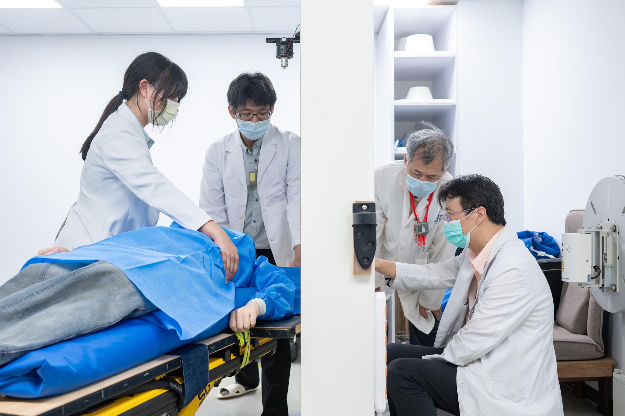 NTHU nuclear engineers Jinn-Jer Peir (second from right) and Yung-Shin Tseng (second from left), along with TVGH physician Yi-Wei Chen (right), simulate the positioning of the neutron beam irradiation field for a breast cancer patient.