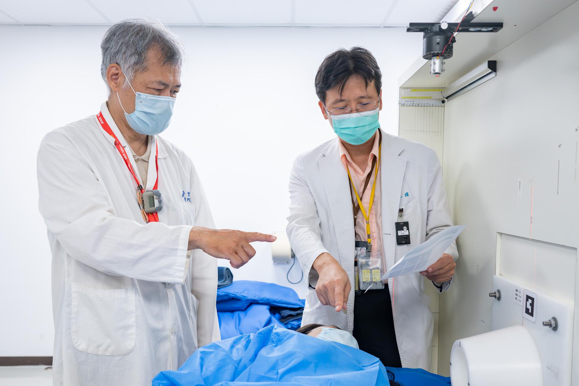 Nuclear engineer Jinn-Jer Peir (left), who is responsible for treatment planning, discusses the BNCT treatment process for a breast cancer patient with physician Yi-Wei Chen (right).