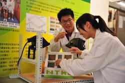 Members of the research team working on the LEGO house fitted with ordinary glass and graphene smart glass.