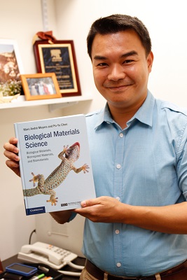 Po-Yu Chen holding up his recently published textbook.