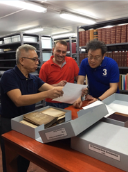 Members of the research team examining ancient manuscripts held in the archives of the University of Santo Tomas.