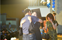 Graduate Yan Manru, recipient of this year’s Life Champion Award, on stage with her parents.