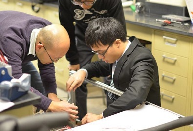 Team members trying out one of their designs, supervised    by  Professors  of  the Hosting University, MU.